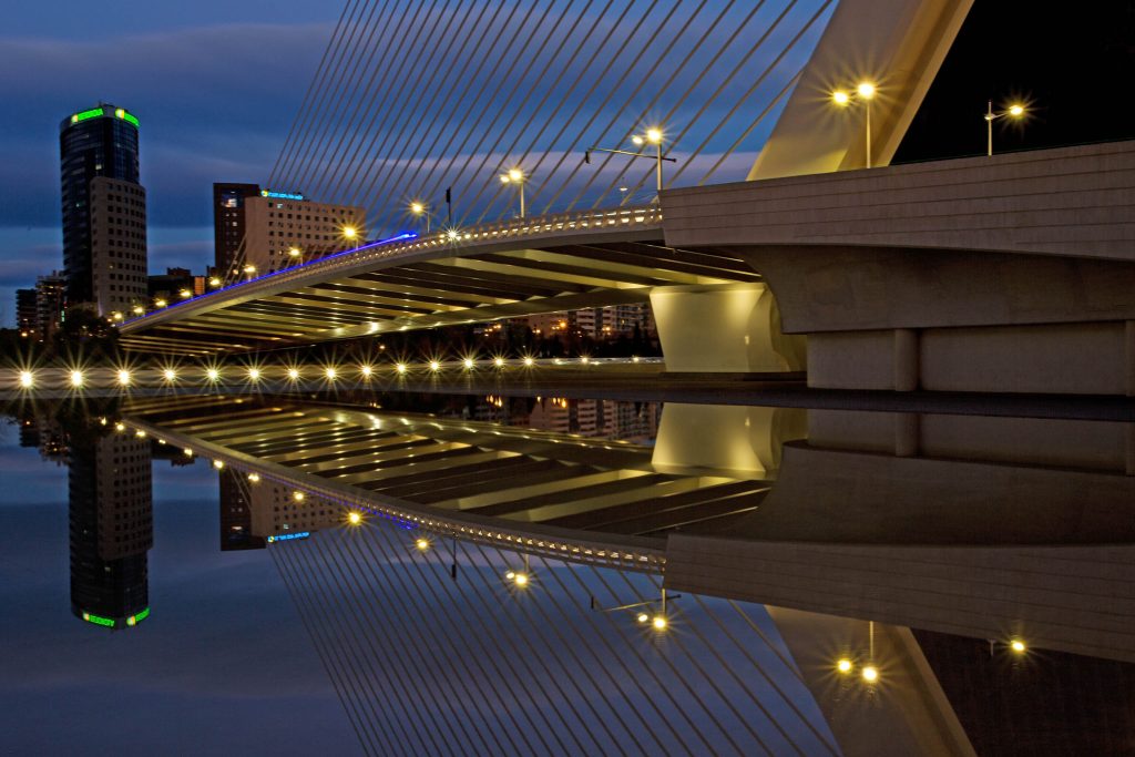 Beleuchtete Brücke spiegelt sich im Wasser